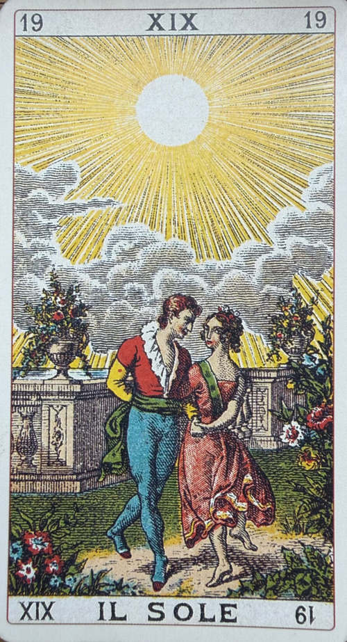 Tarot card titled 'Il Sole' with a bright sun and two people embracing on a wooden surface. the sun tarot card, psychic tarot reading. london psychic 